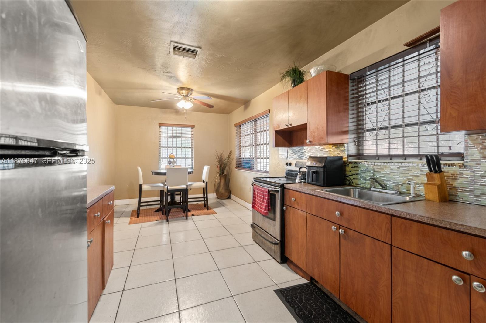 3265 Northwest 50th Street Miami, FL 33142 - Photo 8 of 17 a kitchen with stainless steel appliances granite countertop a stove a sink and a microwave