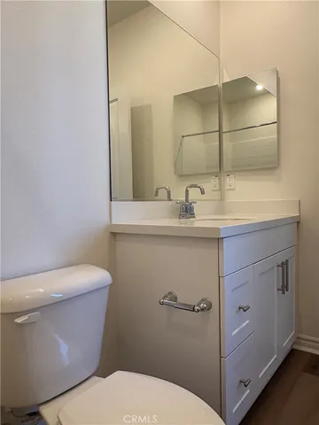 a bathroom with a granite countertop toilet sink and mirror