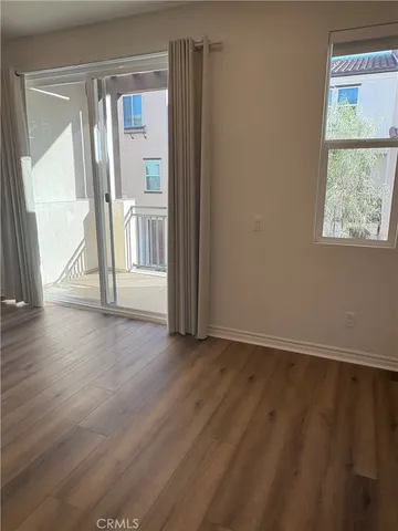 an empty room with wooden floor and a window