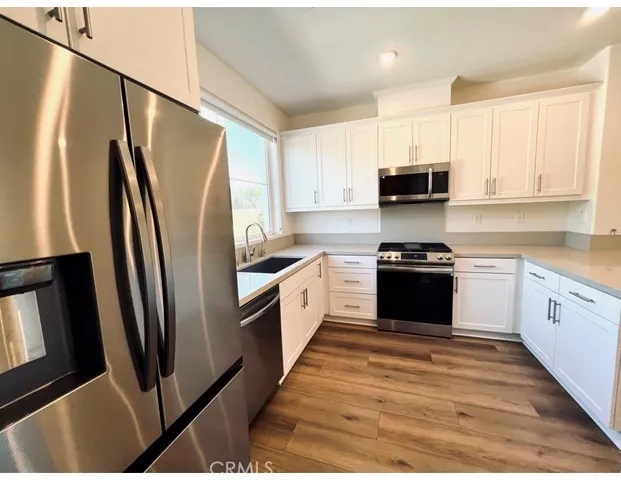 a kitchen with stainless steel appliances a refrigerator sink and a stove
