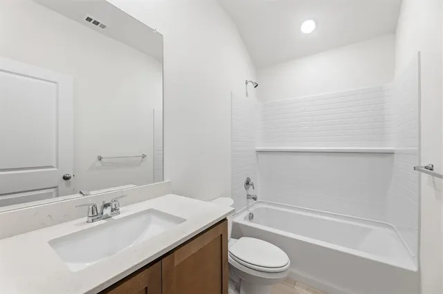 a bathroom with a bathtub shower sink vanity and toilet