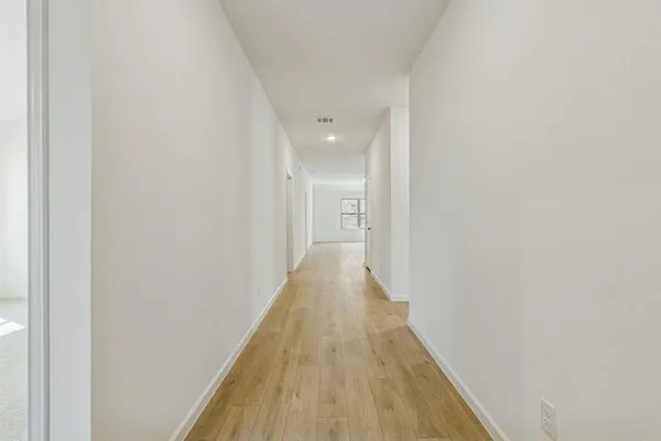 a view of a hallway with wooden floor