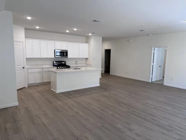 a kitchen with stainless steel appliances a refrigerator sink and microwave