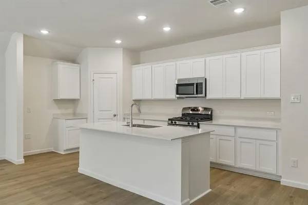 a kitchen with stainless steel appliances granite countertop a sink and dishwasher a stove top oven with wooden floor