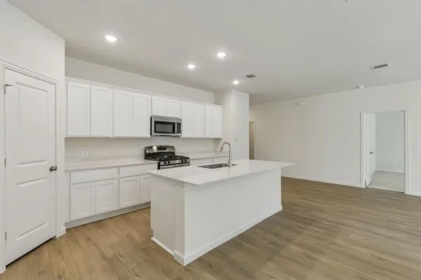 a kitchen with stainless steel appliances granite countertop a white stove top oven and white cabinets