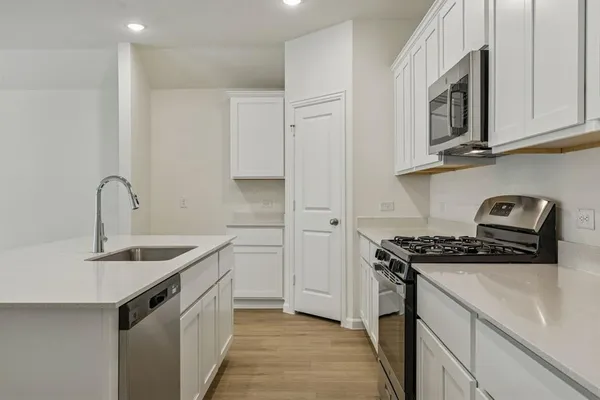 a kitchen with stainless steel appliances granite countertop a sink stove and cabinets