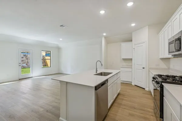 a kitchen with granite countertop a sink and a stove top oven