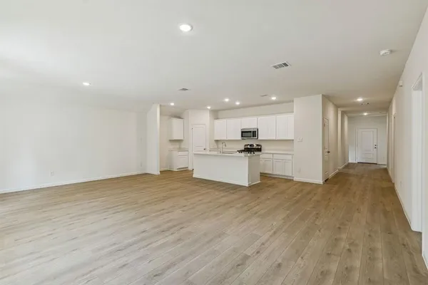 a view of kitchen with kitchen island wooden floor center island and stainless steel appliances