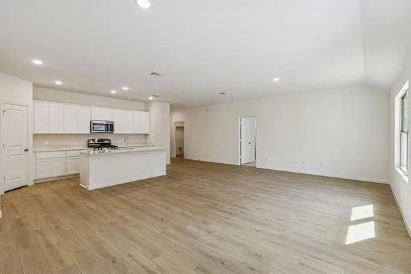 a view of kitchen with granite countertop sink and refrigerator