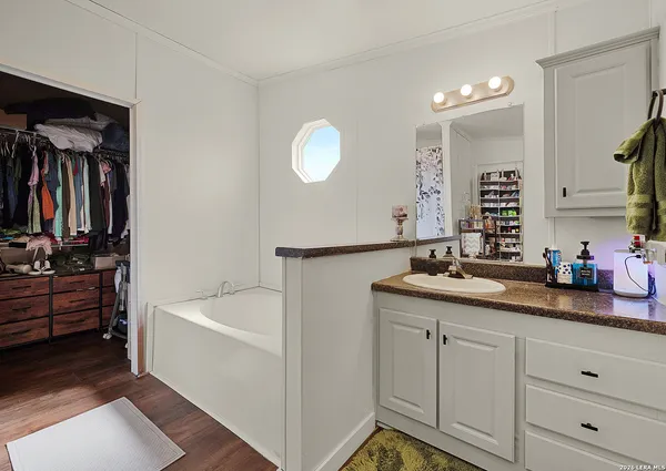 a bathroom with a tub sink and mirror