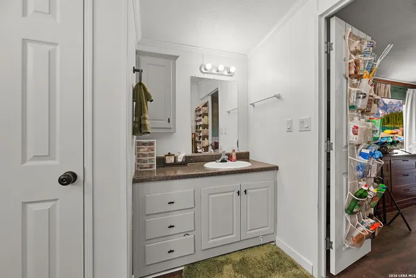 a en suite bathroom with a granite countertop sink and a mirror