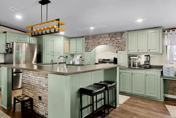 a kitchen with stainless steel appliances granite countertop a stove a sink and a refrigerator