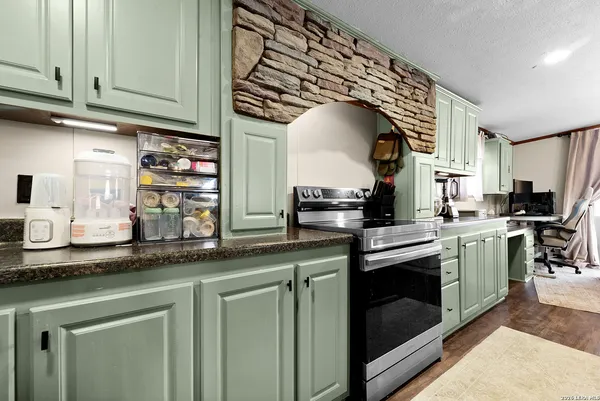 a kitchen with stainless steel appliances granite countertop a sink a stove and cabinets