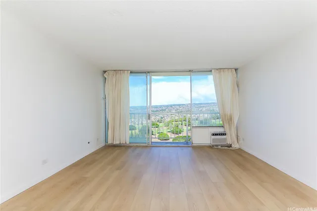 an empty room with wooden floor and a window