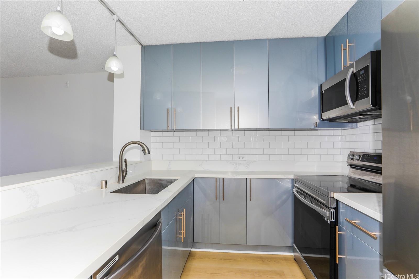98-410 Koauka Loop, Unit 32C Aiea, HI 96701 - Photo 9 of 25 a kitchen with stainless steel appliances a sink a stove and microwave