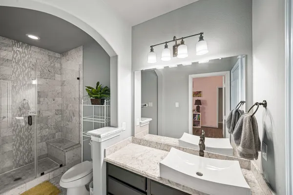 a bathroom with a sink a toilet and shower