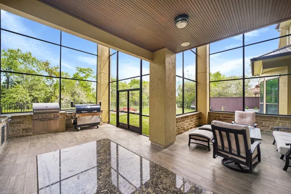 a living room with furniture tv and large windows