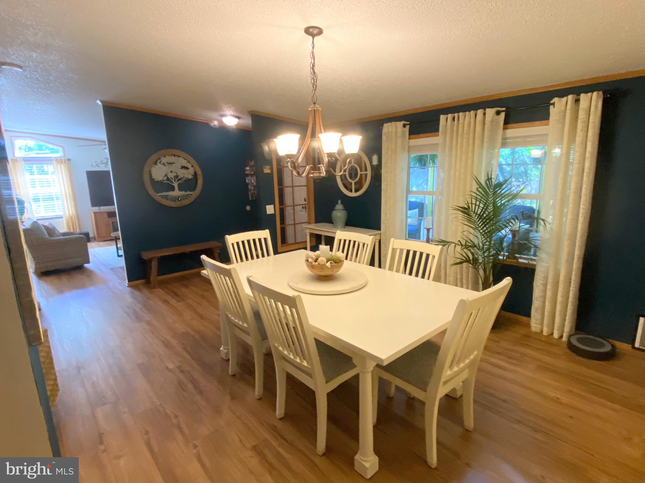 26750 North Rim Road, Unit 975 Long Neck, DE 19966 - Photo 12 of 44 a view of a dining room with furniture window and wooden floor