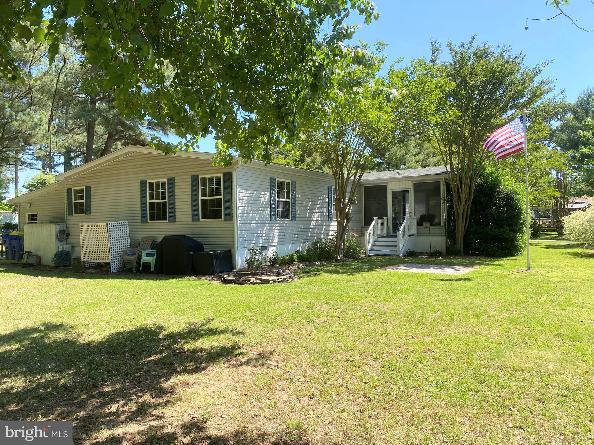 26750 North Rim Road, Unit 975 Long Neck, DE 19966 - Photo 30 of 44 a front view of house with yard and trees