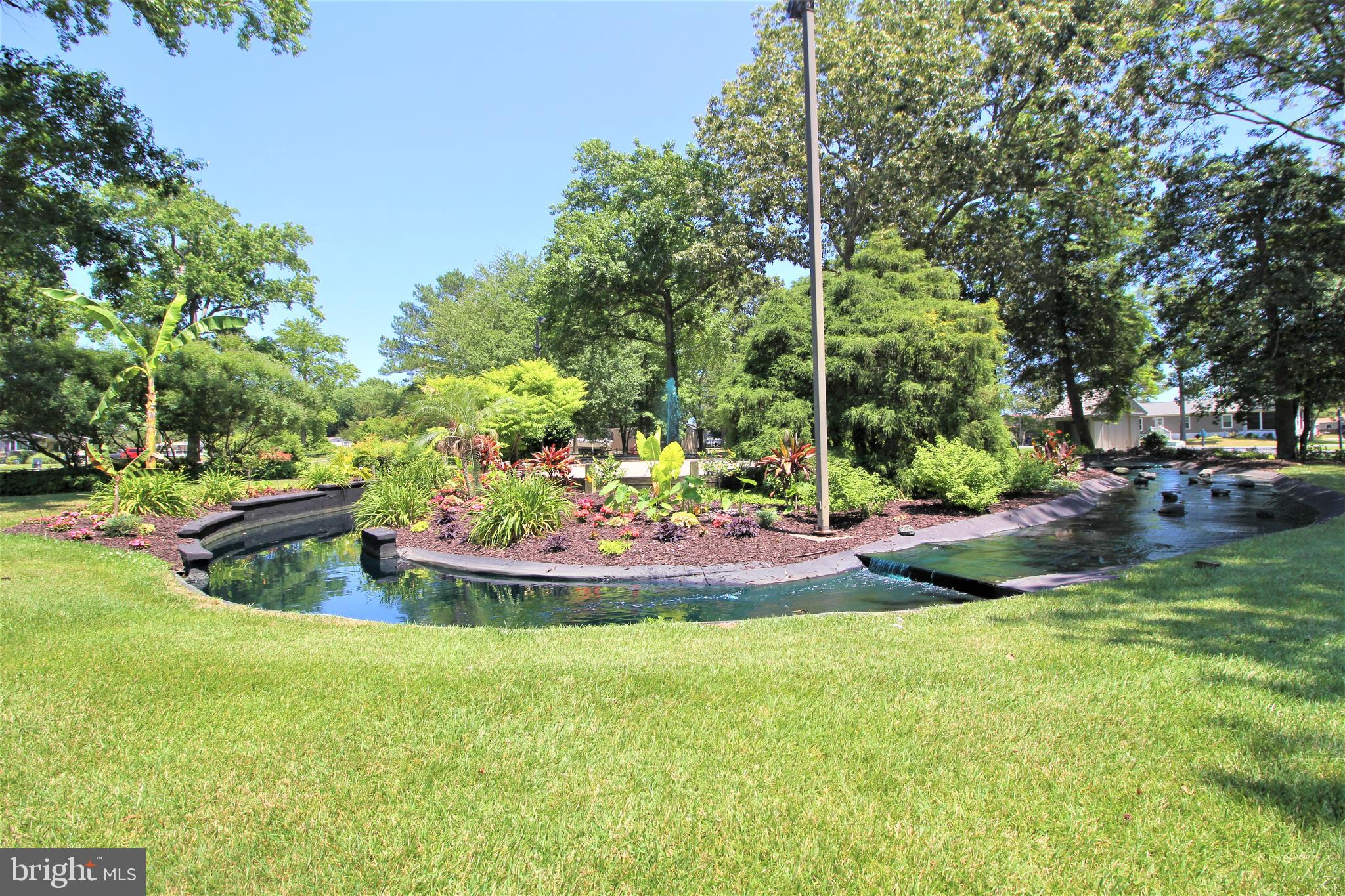 26750 North Rim Road, Unit 975 Long Neck, DE 19966 - Photo 36 of 44 a view of a backyard with plants and patio