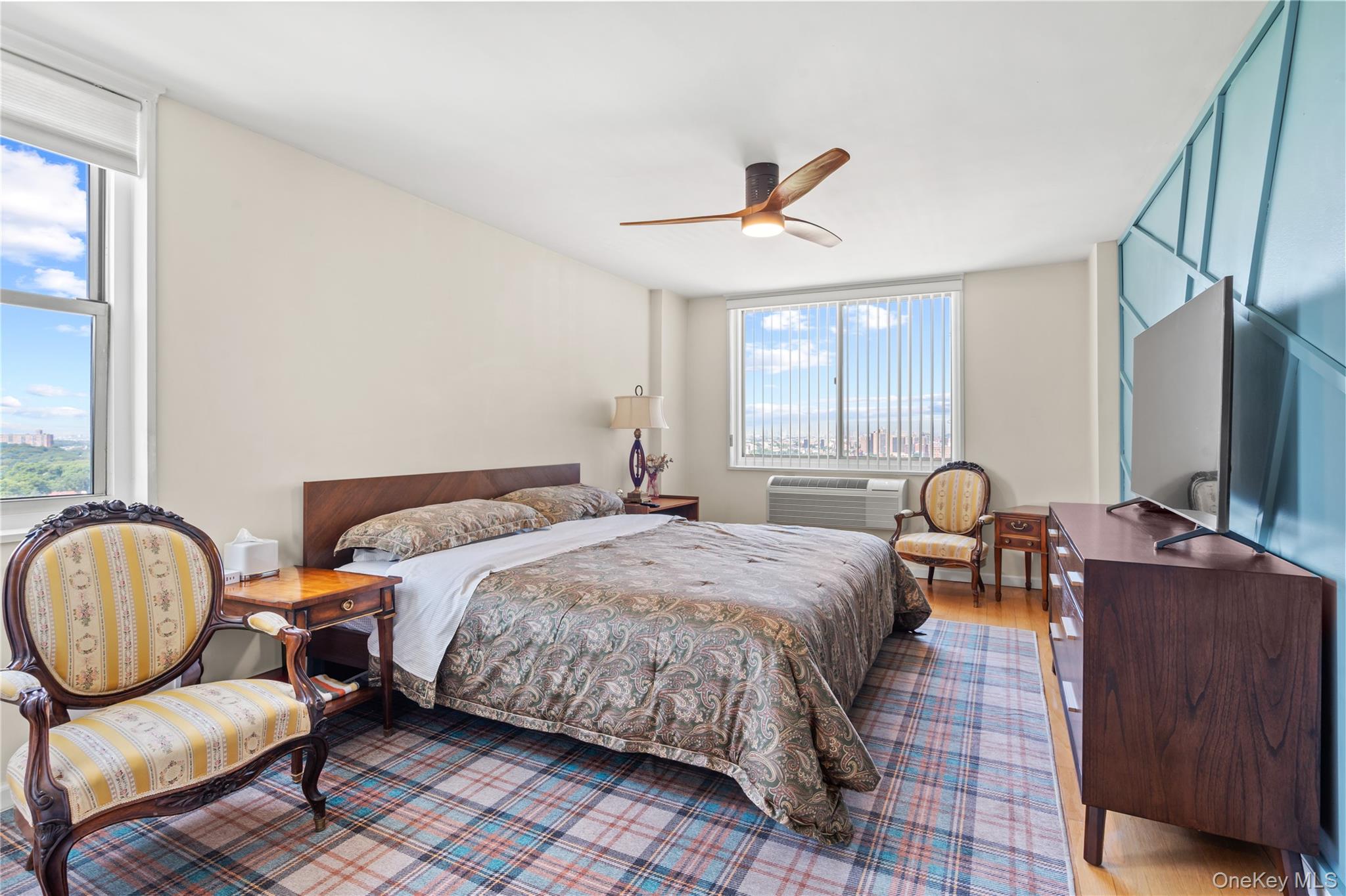 118-18 Union Turnpike, Unit 19G Queens, NY 11415 - Photo 7 of 16 Bedroom with wood finished floors, a ceiling fan, and a wall of windows