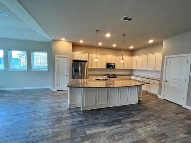 a kitchen with stainless steel appliances granite countertop wooden cabinets a sink and dishwasher