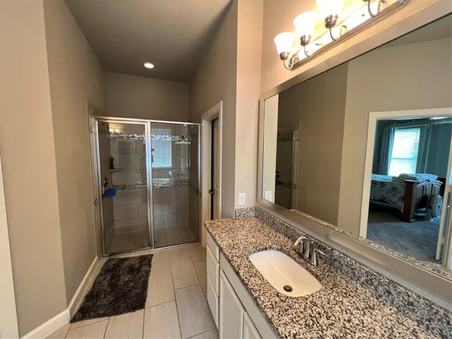 a bathroom with a granite countertop sink and a mirror