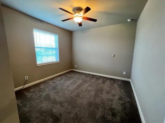 a view of a house with a yard potted plants and a large tree
