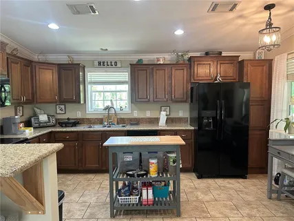 a kitchen with stainless steel appliances granite countertop a refrigerator and a sink
