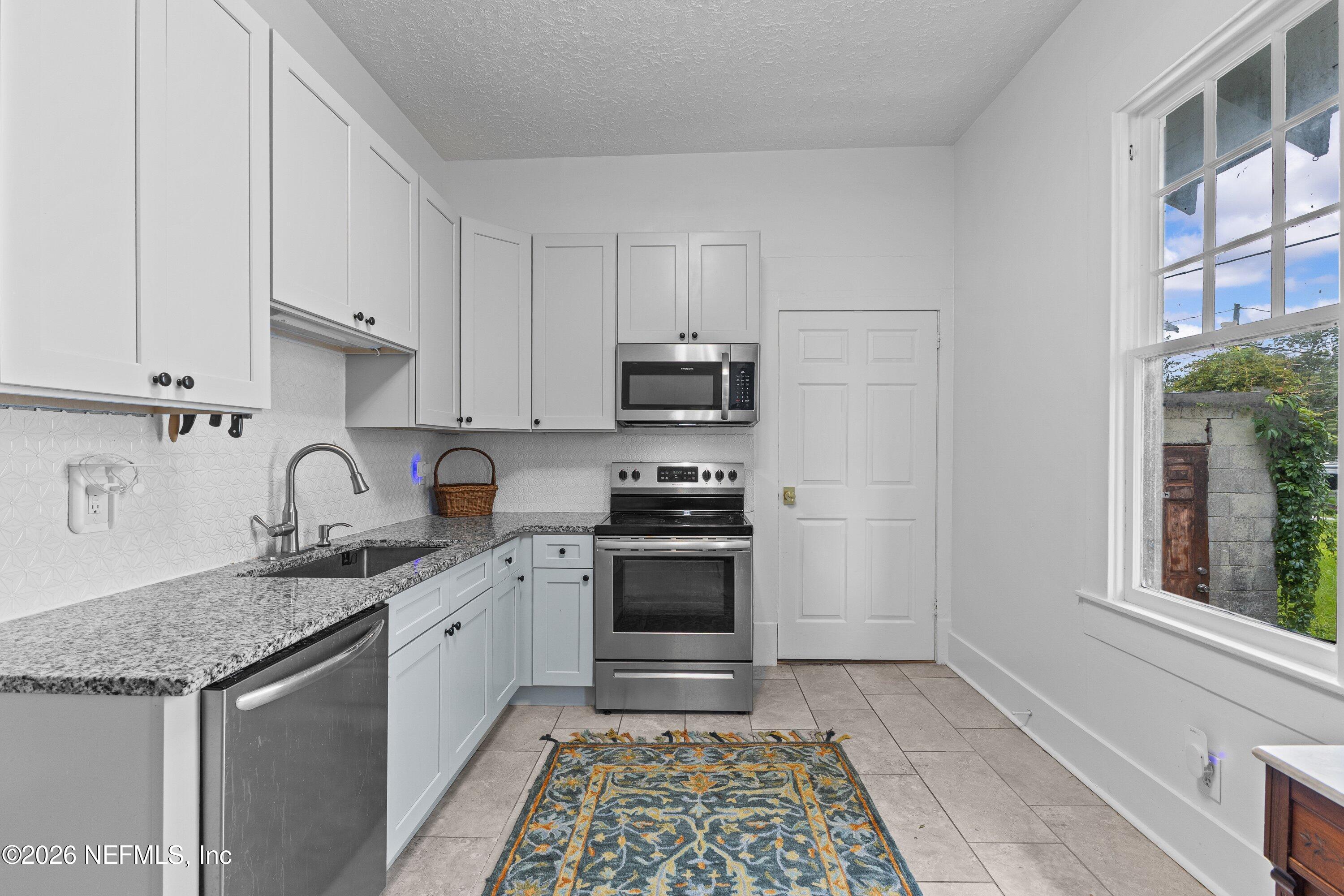 1544 Perry Street Jacksonville, FL 32206 - Photo 28 of 43 a kitchen with granite countertop a sink stainless steel appliances and cabinets