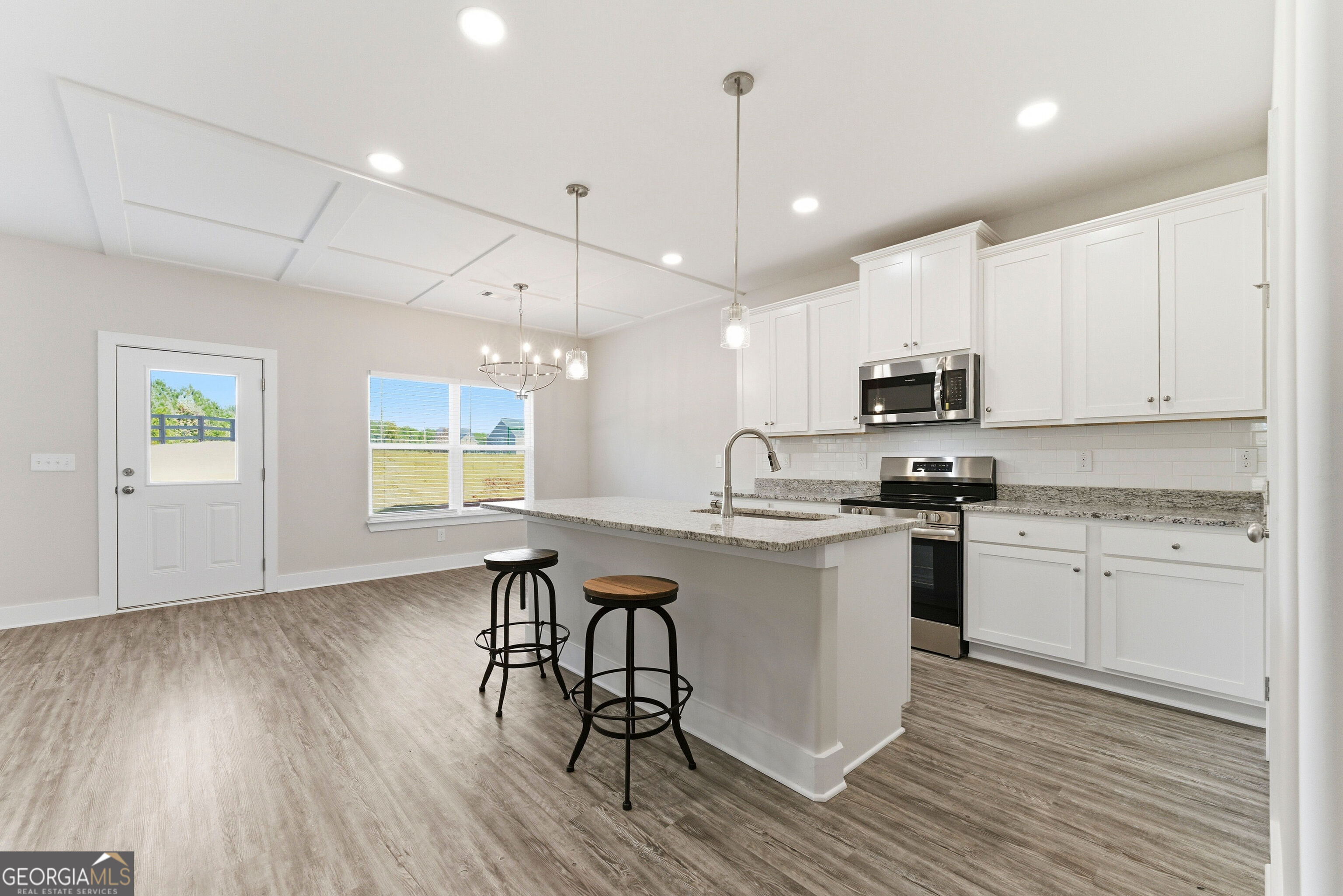 11209 Cornerstone Lane Hampton, GA 30228 - Photo 16 of 38 a kitchen with stainless steel appliances granite countertop a sink a stove a refrigerator and white cabinets with wooden floor