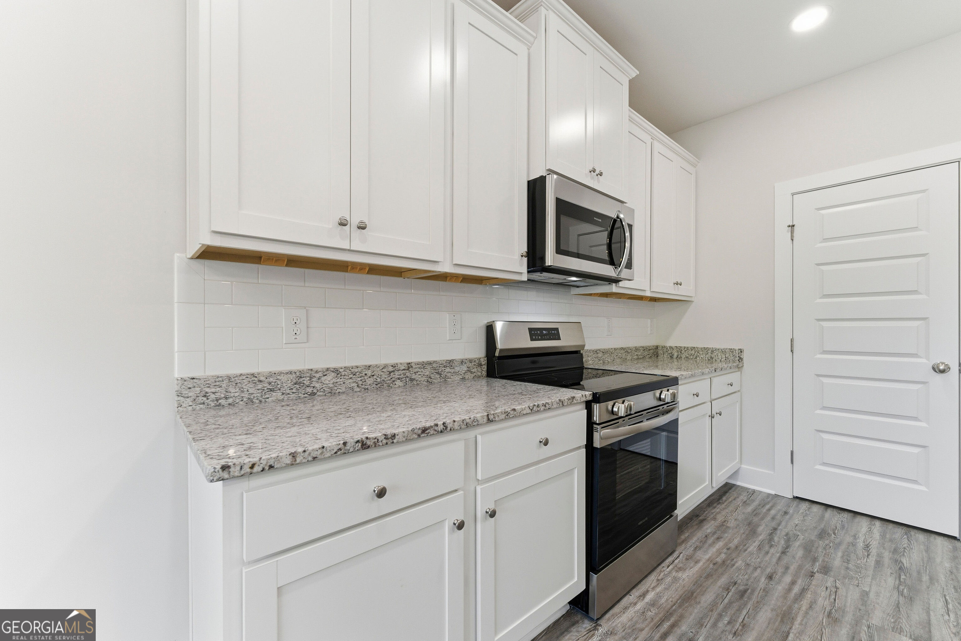 11209 Cornerstone Lane Hampton, GA 30228 - Photo 21 of 38 a kitchen with stainless steel appliances granite countertop white cabinets stove a sink and dishwasher