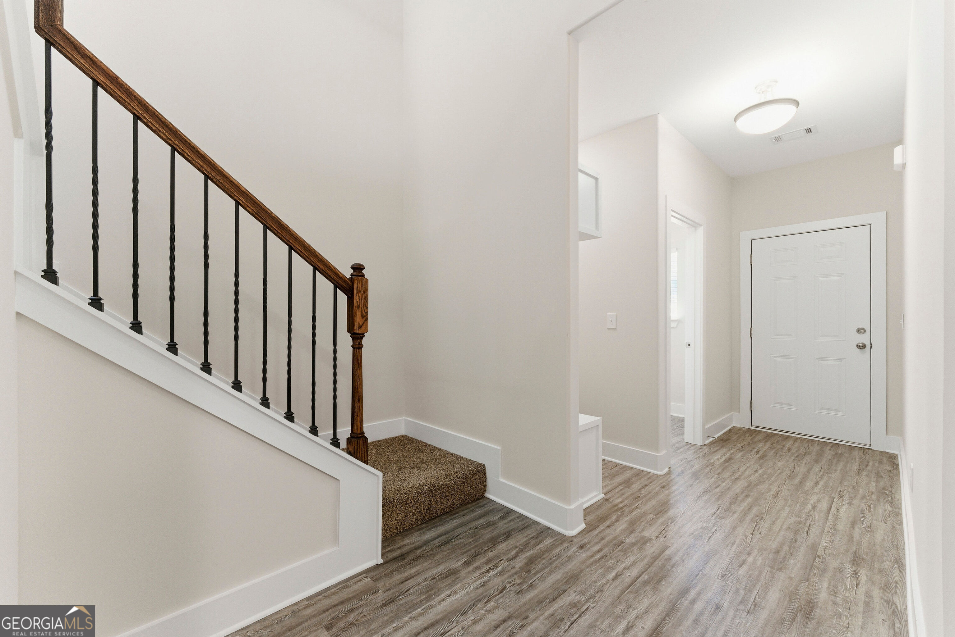 11209 Cornerstone Lane Hampton, GA 30228 - Photo 7 of 38 a view of a hallway with wooden floor and staircase