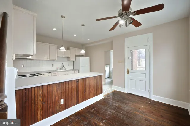 a kitchen with kitchen island white cabinets and refrigerator