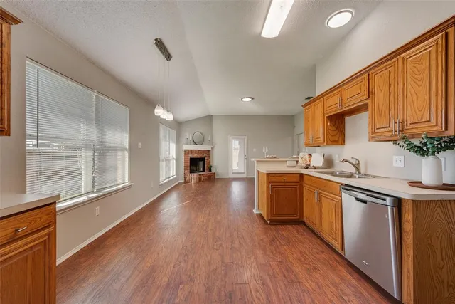 a kitchen with sink a stove and wooden floor