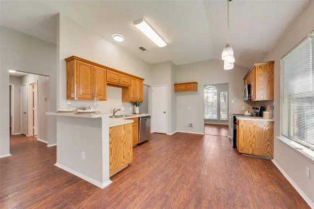 a kitchen with stainless steel appliances granite countertop wooden floors and white cabinets