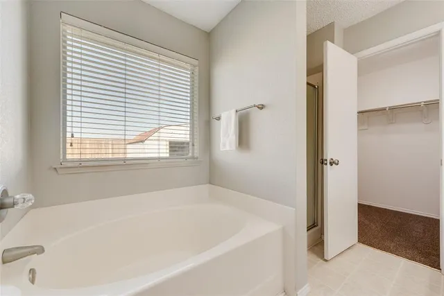 a white bath tub sitting in a bathroom next to a window