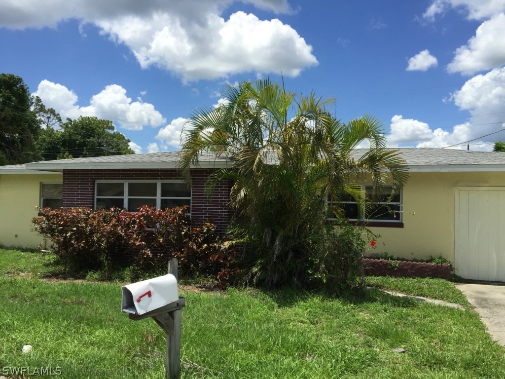 2205 Carrell Road Fort Myers, FL 33901 - Photo 1 of 1 a front view of house with garden and trees