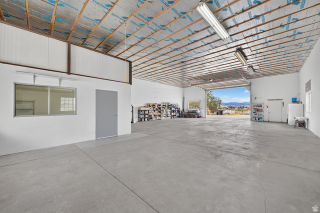 4468 North Droubay Road Tooele, UT 84074 - Photo 42 of 60 Expansive open-concept interior featuring concrete flooring, exposed ceiling beams, and integrated fluorescent lighting