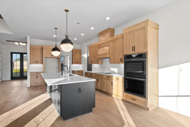 a kitchen with stainless steel appliances a stove a sink and a refrigerator