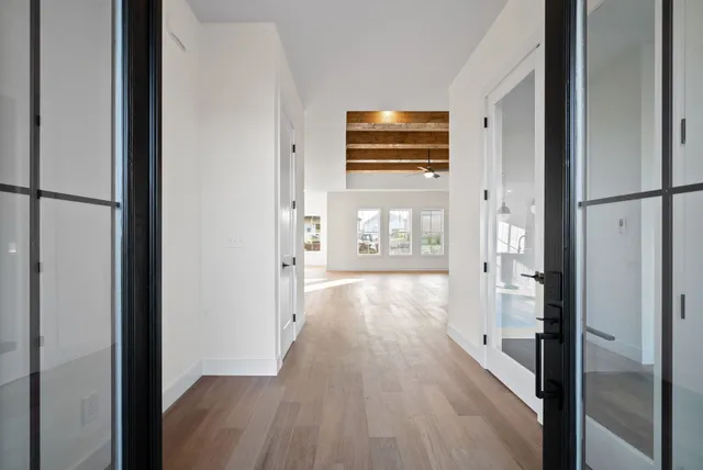 a view of a hallway with wooden floor windows and livingroom