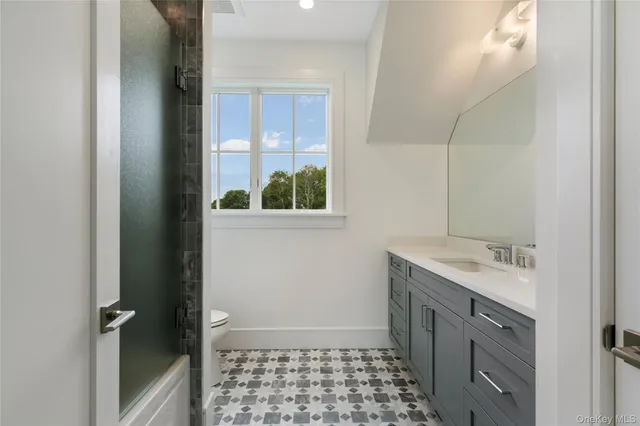 a bathroom with a sink a toilet and window