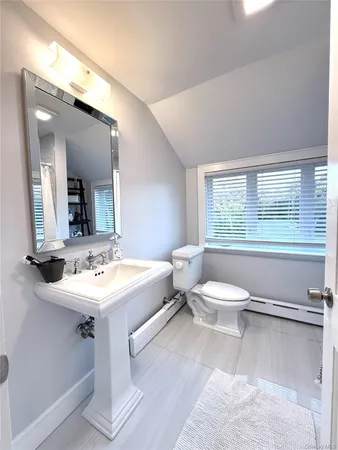 a bathroom with a toilet a sink and mirror