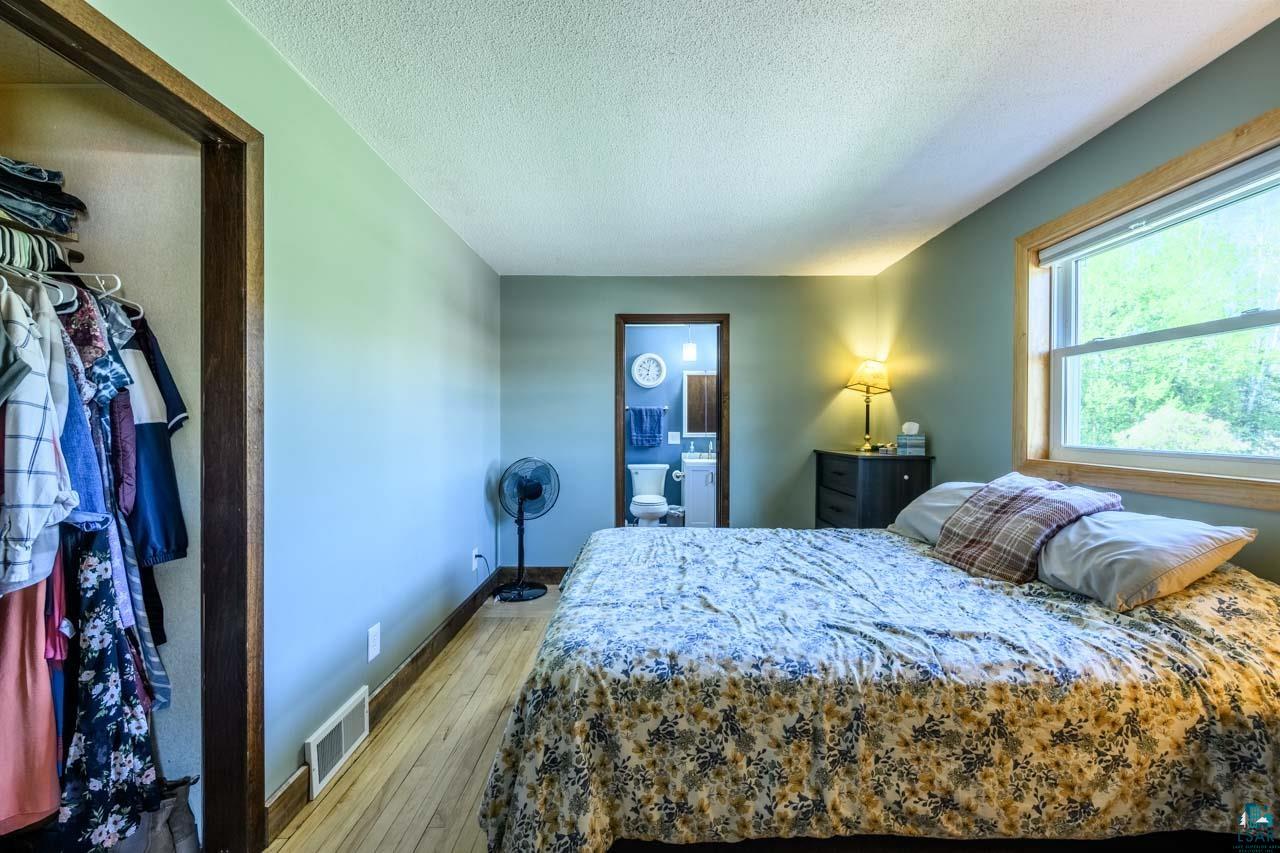 2581 O'Rourke Road Hibbing, MN 55746 - Photo 13 of 61 Bedroom featuring wood-finish flooring and a window with wood trim