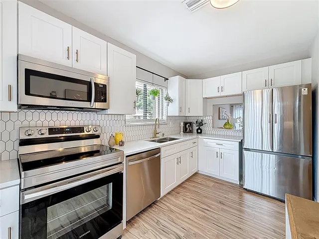a kitchen with granite countertop a refrigerator stove and microwave