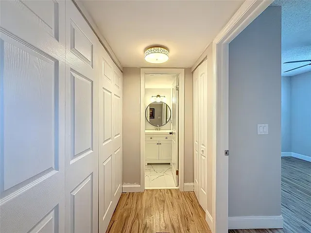 a view of a hallway with wooden floor and closet