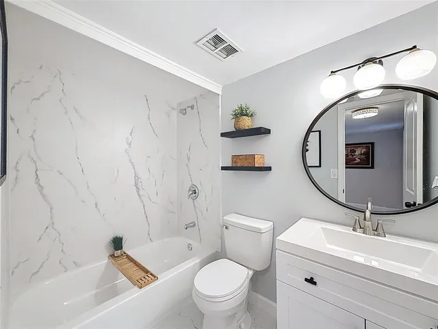 a bathroom with a toilet sink and mirror