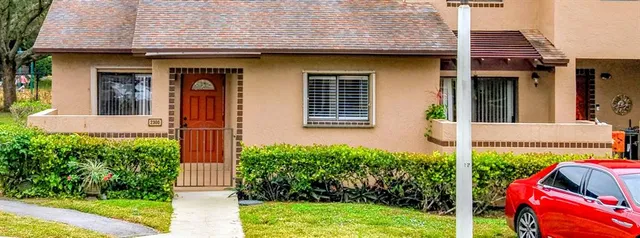 a view of a house with small yard plants and a lawn chair