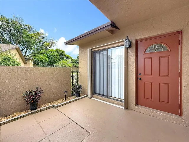 front view of a house with a potted plant and floor to ceiling window