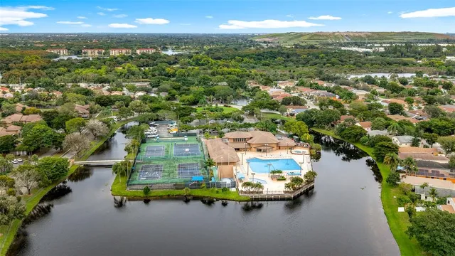 an aerial view of a house with a yard lake lake and city view